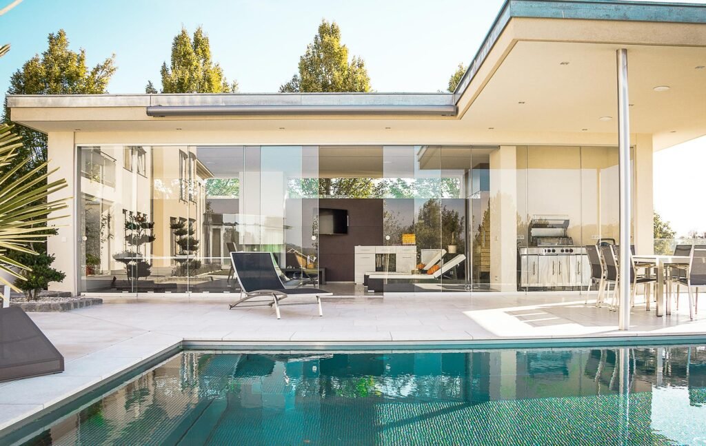 asa moderna con alberca, terraza techada y área exterior con sala al aire libre.